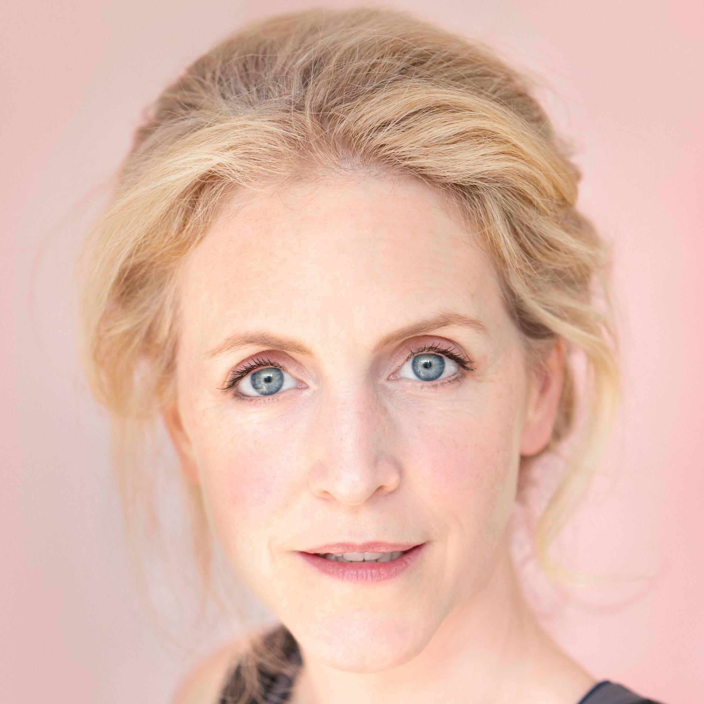 Headshot of Marianne Oldham. She is a white woman with blonde hair in a loose plait and blue eyes.